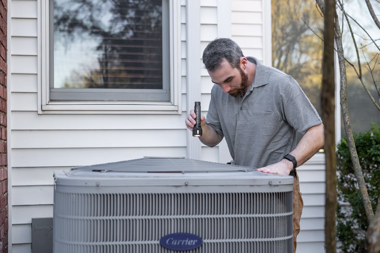 Field technician inspecting outdoor equipment at a customer's home